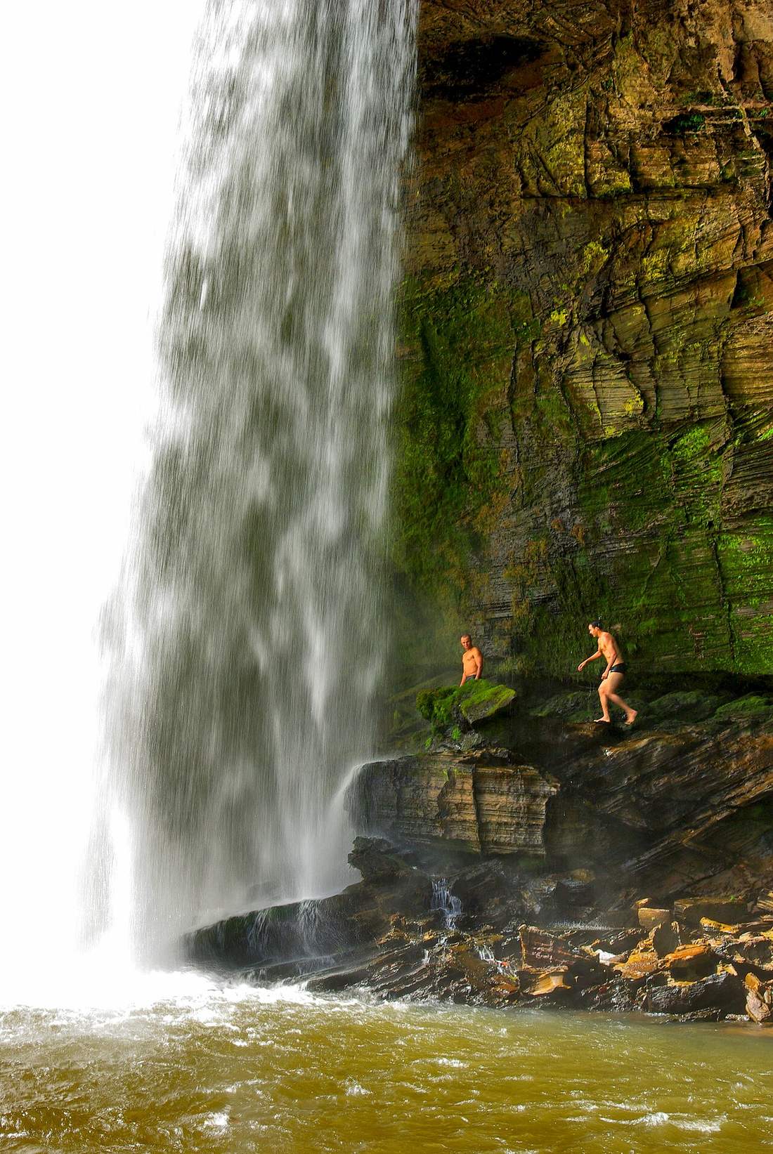Dos viajeros bajo la cortina de agua de la cachoeira de São Romão
